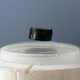 Un imán levitando sobre un superconductor enfriado mediante nitrógeno líquido, una de las aplicaciones más visuales de la superconductividad llamada Efecto Meissner.